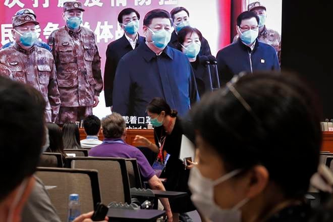Beijing : Journalists chat near a screen showing President Xi Jinping talks by video with patients and medical workers at the Huoshenshan Hospital in Wuhan in central China's Hubei Province before a press conference for the white paper on fighting Covid-19 China in action which chaired by Xu Lin, vice head of the publicity department of the communist party, at the State Council Information Office in Beijing, Sunday, June 7, 2020. Senior Chinese health officials defended their country's response to the new coronavirus pandemic, saying they provided information in a timely and transparent manner. AP/PTI Photo(AP07-06-2020_000043A)