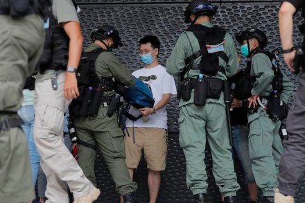 Riot police checks a man near the U.S. Consulate in Hong Kong, Saturday, July 4, 2020 to mark the American Independence Day or "the Fourth of July." China's government and pro-Beijing activists in Hong Kong are condemning what they call foreign meddling in the territory's affairs, as countries move to offer Hong Kongers refuge and impose sanctions on China over a new security law. (AP Photo/Kin Cheung)