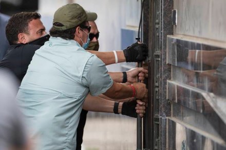 Federal officials and a locksmith pull on a door to make entry into the vacated Consulate General of China building Friday, July 24, 2020, in Houston. On Tuesday, the U.S. ordered the Houston consulate closed within 72 hours, alleging that Chinese agents had tried to steal data from facilities in Texas, including the Texas A&M medical system and The University of Texas MD Anderson Cancer Center in Houston. (Brett Coomer/Houston Chronicle via AP)