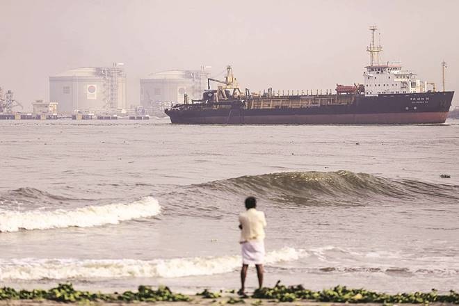 A man looks out to sea as the DCI Dredge XV hopper dredger, operated by Dredging Corp. of India Ltd., travels past the Kochi LNG Terminal, operated by Petronet LNG Ltd., at Cochin port in Cochin, India, on Saturday, May 30, 2015. India is gearing up for a deficient monsoon for a second year, signaling record food imports, efforts to cushion farmers and contingencies for lower hydroelectricity. Photographer: Dhiraj Singh/Bloomberg A man looks out to sea as the DCI Dredge XV hopper dredger, operated by Dredging Corp. of India Ltd., travels past the Kochi LNG Terminal, operated by Petronet LNG Ltd., at Cochin port in Cochin, India, on Saturday, May 30, 2015. India is gearing up for a deficient monsoon for a second year, signaling record food imports, efforts to cushion farmers and contingencies for lower hydroelectricity. Photographer: Dhiraj Singh/Bloomberg