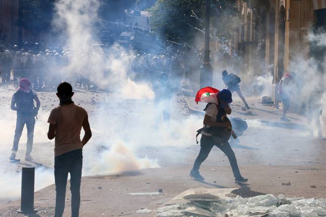 Demonstrators take part in a protest amid a cloud of tear gas fired by police, following Tuesday's blast, in Beirut, Lebanon August 8, 2020. REUTERS/Aziz Taher