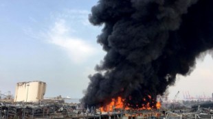A column of black smoke billowed from the port at midday Thursday, with orange flames leaping from the ground.