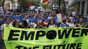 A file photo of people carrying a banner reading ‘Empower The Future’ during a demonstration in London. Policies in the so-called free enterprise economies are always skewed towards capitalists, the author says bloomberg