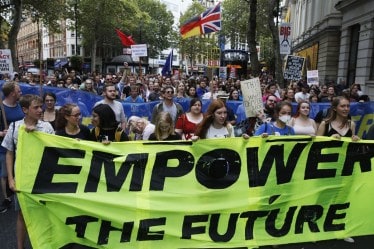 A file photo of people carrying a banner reading ‘Empower The Future’ during a demonstration in London. Policies in the so-called free enterprise economies are always skewed towards capitalists, the author says bloomberg