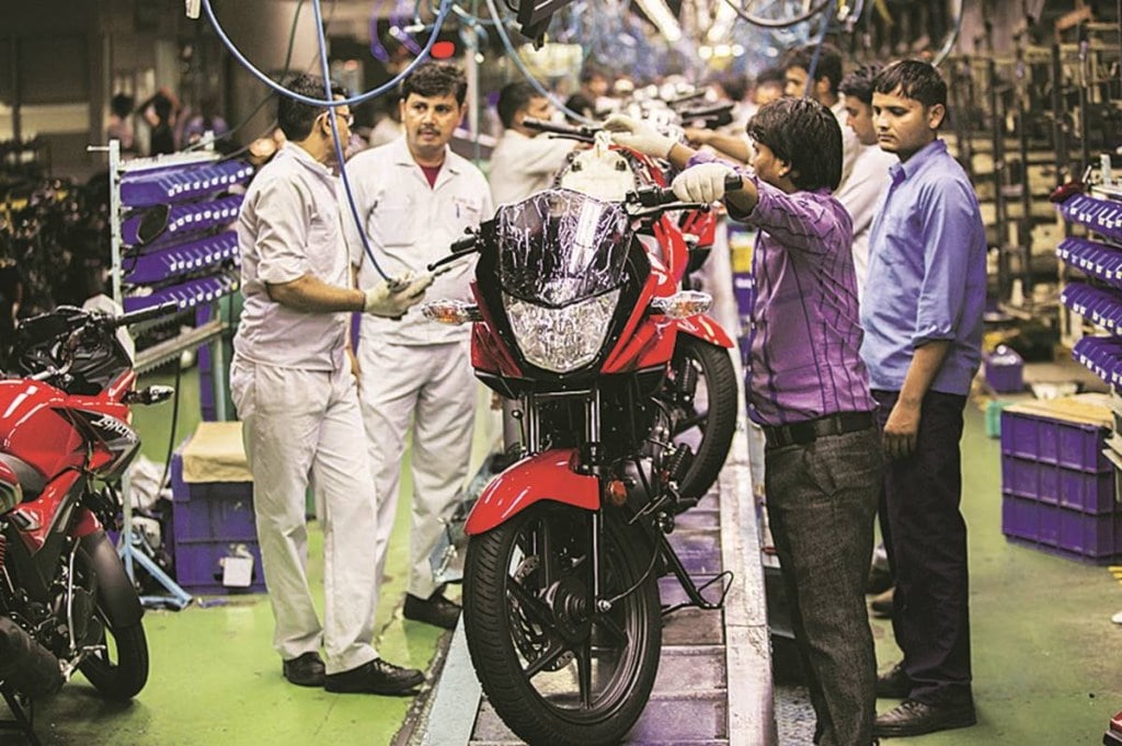 Workers assemble Hero Ignitor motorcycles on the assembly line of the Hero MotorCorp Ltd. manufacturing facility in Gurgaon, India, on Wednesday, June 11, 2014. India’s industrial production data for April is scheduled for release on June 12. Photographer: Prashanth Vishwanathan/Bloomberg