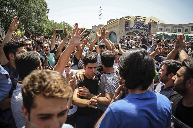 FILE - In this June 25, 2018 file photo, a group of protesters chant slogans at the main gate of the Old Grand Bazaar, in Tehran, Iran. On Saturday, Sept. 5, 2020, Iran broadcast the televised confession of a wrestler facing the death penalty after a tweet from President Donald Trump criticizing the case, a segment that resembled hundreds of other suspected coerced confessions aired over the last decade in the Islamic Republic. The case of 27-year-old Navid Afkari has drawn the attention of a social media campaign that portrays him and his brothers as victims targeted over participating in protests against Iran's Shiite theocracy in 2018. (Iranian Labor News Agency via AP, File) FILE - In this June 25, 2018 file photo, a group of protesters chant slogans at the main gate of the Old Grand Bazaar, in Tehran, Iran. On Saturday, Sept. 5, 2020, Iran broadcast the televised confession of a wrestler facing the death penalty after a tweet from President Donald Trump criticizing the case, a segment that resembled hundreds of other suspected coerced confessions aired over the last decade in the Islamic Republic. The case of 27-year-old Navid Afkari has drawn the attention of a social media campaign that portrays him and his brothers as victims targeted over participating in protests against Iran's Shiite theocracy in 2018. (Iranian Labor News Agency via AP, File)