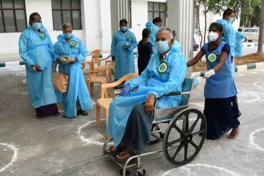 A COVID-19 recovered patient moves out on a wheelchair after being discharged from a hospital, in Chennai. (PTI Photo)