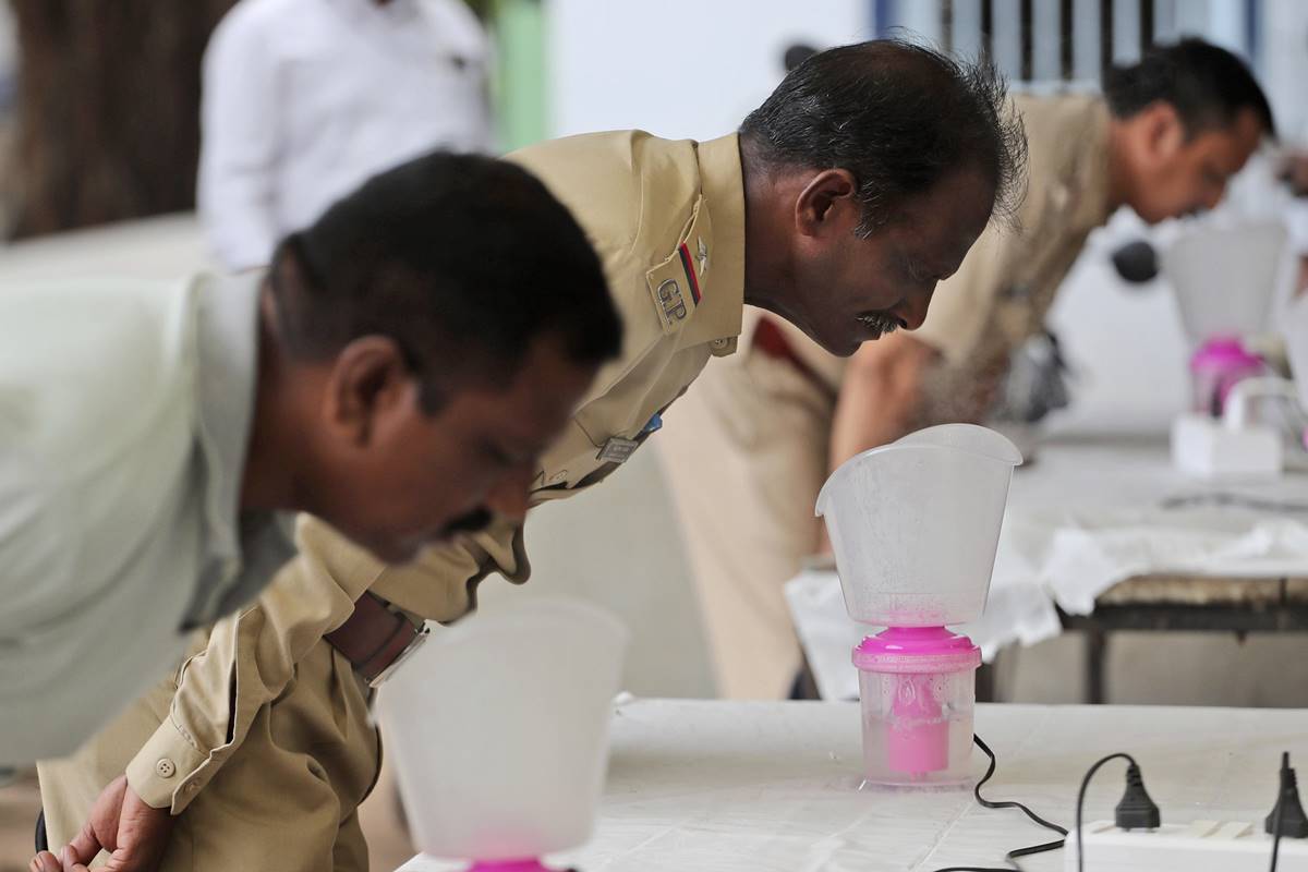 Policemen inhale steam at steam stations set up outside the office of the Commissioner of Police as a precautionary measure against the coronavirus in Ahmedabad. (AP Photo) Policemen inhale steam at steam stations set up outside the office of the Commissioner of Police as a precautionary measure against the coronavirus in Ahmedabad. (AP Photo)