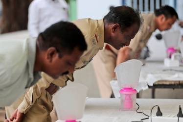 Policemen inhale steam at steam stations set up outside the office of the Commissioner of Police as a precautionary measure against the coronavirus in Ahmedabad. (AP Photo)