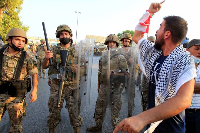 A demonstrator gestures as he stands near a Lebanese army soldier, during anti-government protests near presidential palace in Baabda, Lebanon September 12, 2020. REUTERS/Aziz Taher A demonstrator gestures as he stands near a Lebanese army soldier, during anti-government protests near presidential palace in Baabda, Lebanon September 12, 2020. REUTERS/Aziz Taher