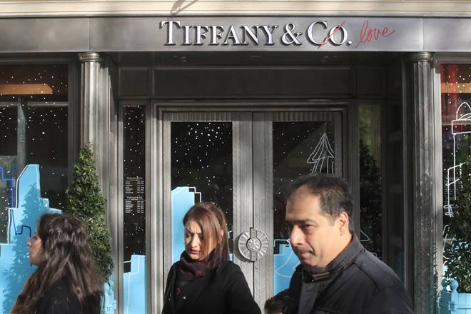 FILE - In this Nov.25, 2019 file photo, people walk past a Tiffany jeweler shop on the Champs Elysees avenue in Paris. LVMH is ending its monthslong pursuit of luxury jewelry retailer Tiffany & Co., citing in part the impact of proposed tariffs on French goods. The Paris-based conglomerate said that it needs more time to assess the impact of U.S. tariffs on French goods and cannot close the deal before year-end. (AP Photo/Michel Euler, File) FILE - In this Nov.25, 2019 file photo, people walk past a Tiffany jeweler shop on the Champs Elysees avenue in Paris. LVMH is ending its monthslong pursuit of luxury jewelry retailer Tiffany & Co., citing in part the impact of proposed tariffs on French goods. The Paris-based conglomerate said that it needs more time to assess the impact of U.S. tariffs on French goods and cannot close the deal before year-end. (AP Photo/Michel Euler, File)