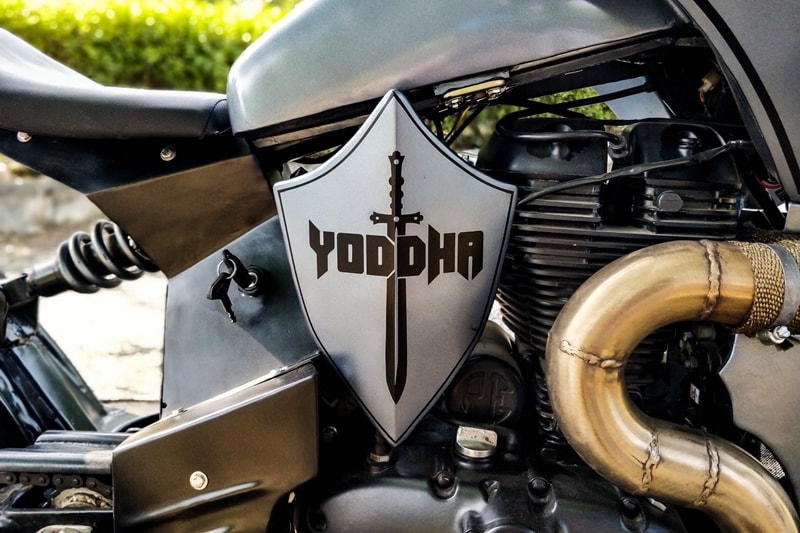 Quite the blend of a bobber and a roadster, the modified Royal Enfield gets a raw metal finish, a knight's shield on one side, and rather a fitting name - Yoddha (warrior). The custom build is based on a Thunderbird 350 but Neev Motorcycles will do it for you on any other Royal Enfield motorcycles as well.