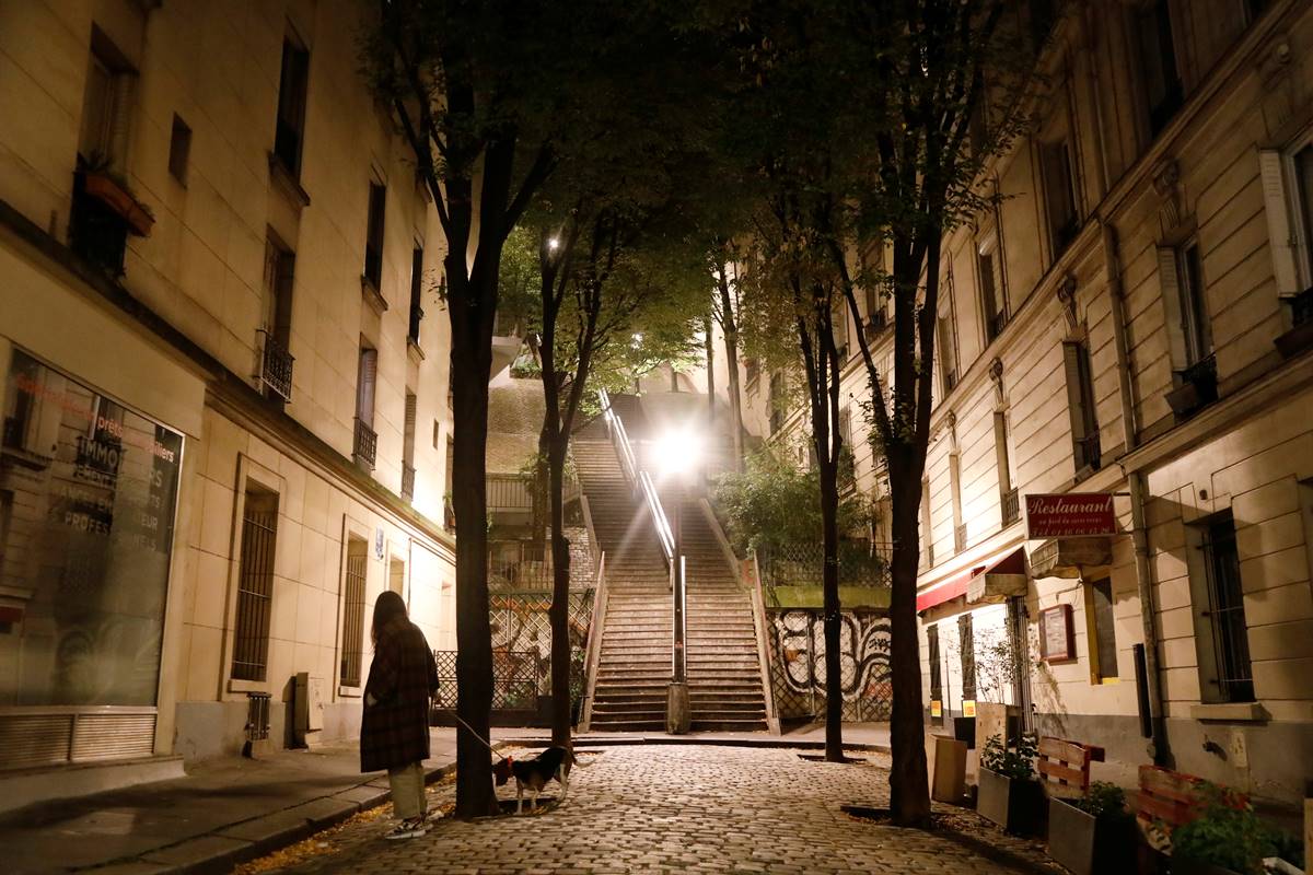 A woman walks her dog in Montmartre during the late-night curfew due to restrictions against the spread of the coronavirus disease (COVID-19) in Paris, France. (Reuters image) A woman walks her dog in Montmartre during the late-night curfew due to restrictions against the spread of the coronavirus disease (COVID-19) in Paris, France. (Reuters image)