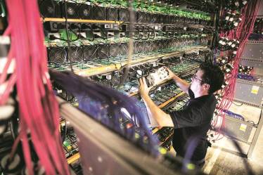 A technician monitors cryptocurrency mining rigs in Quebec, Canada. The author discusses blockchain, which has become quite revolutionary thanks to bitcoin Bloomberg