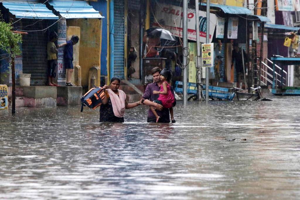 A family wades through a flooded street in Chennai, Tamil Nadu. (AP Photo)