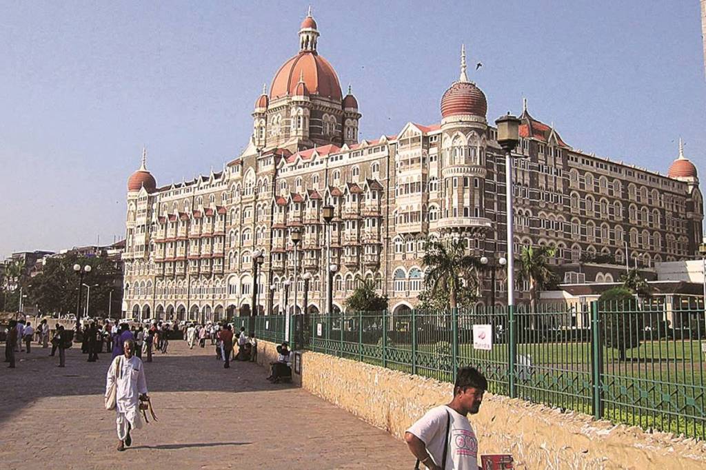 Visitors and residents pass by the famous Taj Mahal Hotel on the waterfront in Mumbai, India November 5, 2004. When privatization was the Indian government's prevailing ideology, the state sold controlling stakes in 22 hotels. Indian Prime Minister Manmohan Singh says his government wouldn't pursue privatization "as an ideology or a panacea." Photographer: Robert Stewart/Bloomberg News Visitors and residents pass by the famous Taj Mahal Hotel on the waterfront in Mumbai, India November 5, 2004. When privatization was the Indian government's prevailing ideology, the state sold controlling stakes in 22 hotels. Indian Prime Minister Manmohan Singh says his government wouldn't pursue privatization "as an ideology or a panacea." Photographer: Robert Stewart/Bloomberg News