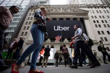 Pedestrians pass in front of the New York Stock Exchange (NYSE) during Uber Inc.'s initial public offering (IPO) in New York, U.S., on Friday, May 10, 2019. The No. 1 ride-hailing company's shares will start trading on the New York Stock Exchange after it raised .1 billion in the biggest U.S. IPO since 2014, pricing shares at each. Photographer: Michael Nagle/Bloomberg
