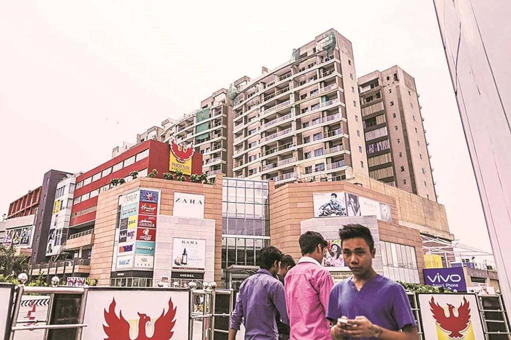 Pedestrians walk past Phoenix Market City shopping mall, developed by Phoenix mills Ltd., in Chennai, India, on Wednesday, July 15, 2015. A banking system flooded with cash is proving the latest challenge in Indian central bank Governor Raghuram Rajan's inflation fight. Photographer: Dhiraj Singh/Bloomberg