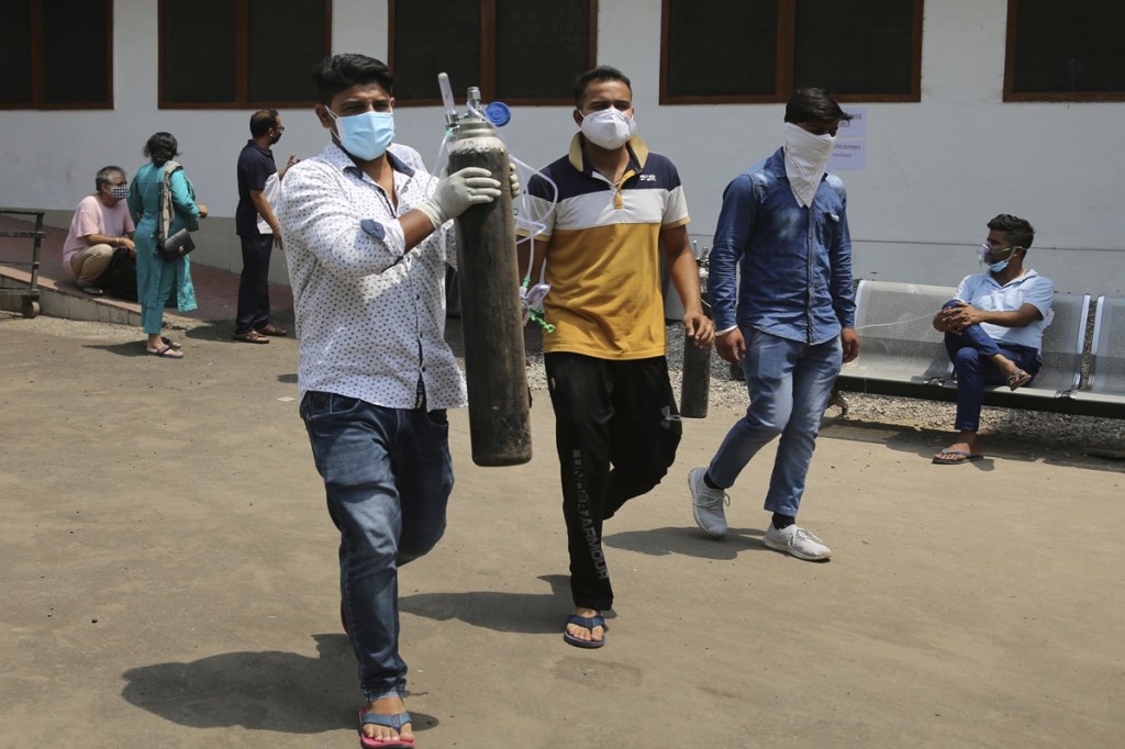 Relatives of a Covid-19 patient carry oxygen cylinder outside a government-run hospital in Jammu AP Relatives of a Covid-19 patient carry oxygen cylinder outside a government-run hospital in Jammu AP