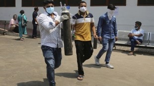 Relatives of a Covid-19 patient carry oxygen cylinder outside a government-run hospital in Jammu AP