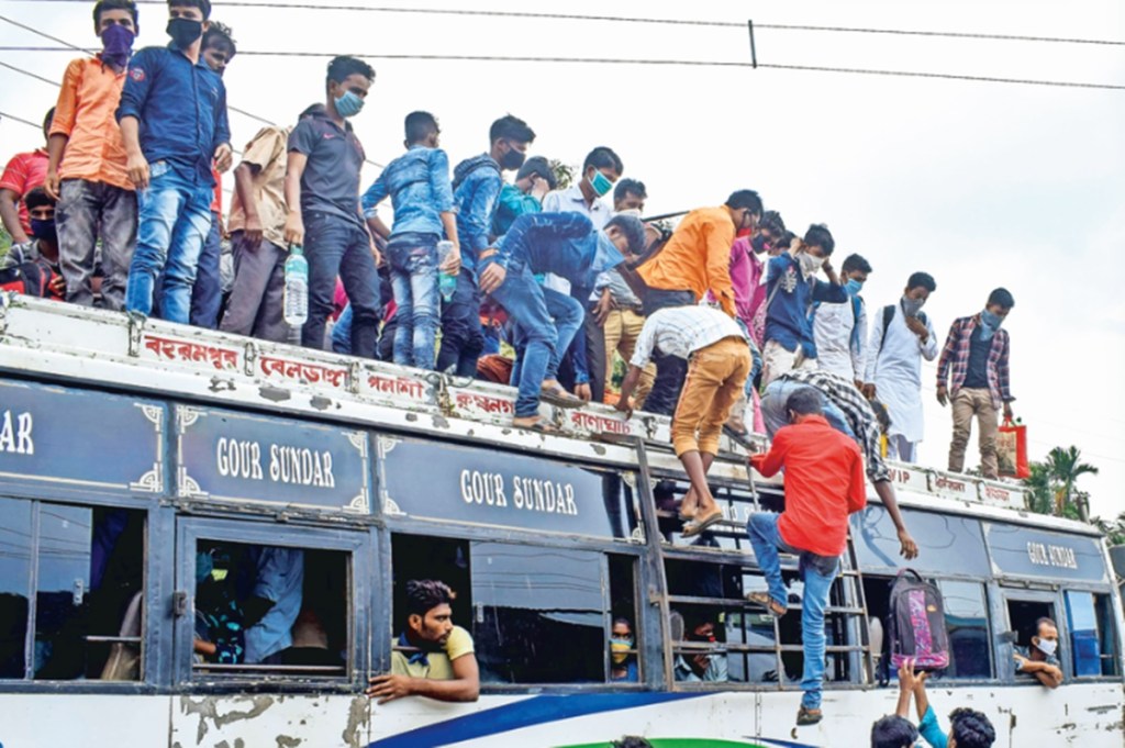 People board a crowded bus in Nadia district in West Bengal on Saturday to leave for their native places (PTI Image)