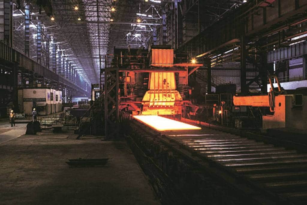 A hot steel slab exits the slab castor as it moves along a conveyor in the plate mill of the Jindal Steel & Power Ltd. plant in Raigarh, Chhattisgargh, India, on Wednesday, Feb. 11, 2015. Jindal Steel manufactures sponge iron, mild steel, and cement. The Company also produces power, conducts mining operations for iron ore and coal, and explores for natural gas and oil. Photographer: Udit Kulshrestha/Bloomberg