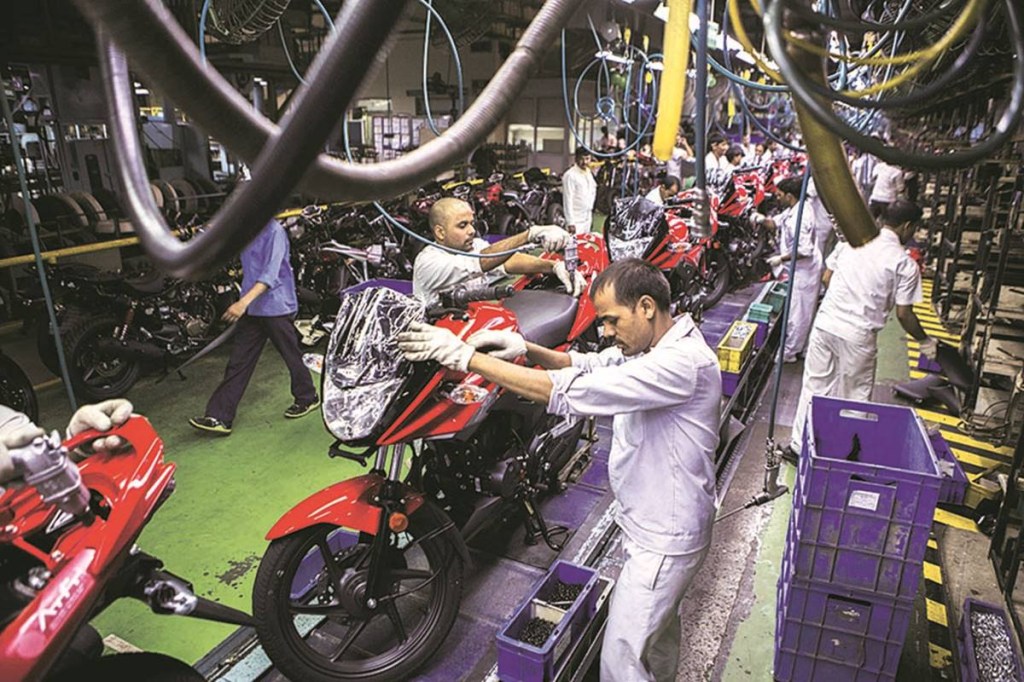 Workers assemble Hero Ignitor motorcycles on the assembly line of the Hero MotorCorp Ltd. manufacturing facility in Gurgaon, India, on Wednesday, June 11, 2014. India’s industrial production data for April is scheduled for release on June 12. Photographer: Prashanth Vishwanathan/Bloomberg