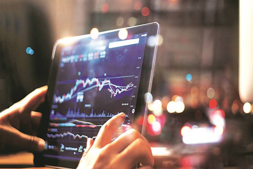 Businessman checking stock market data on tablet on night background Businessman checking stock market data on tablet on night background