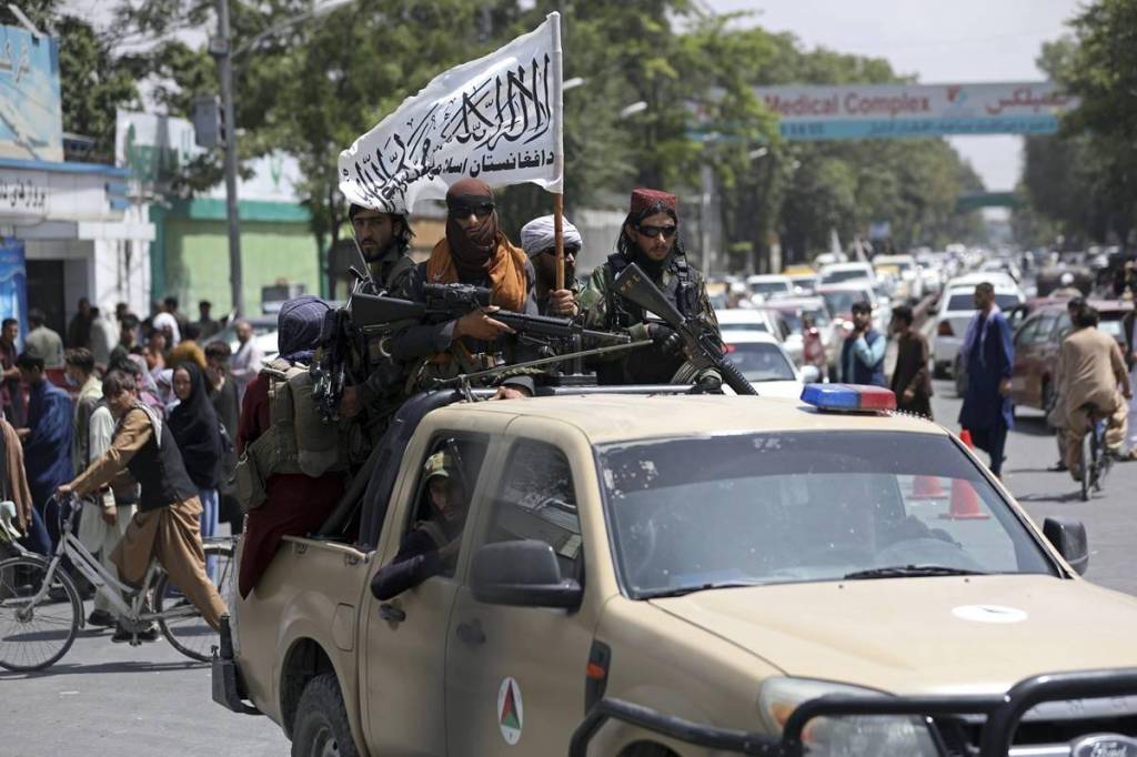 Taliban fighters display their flag as they patrol in Kabul, Afghanistan. (AP Photo)