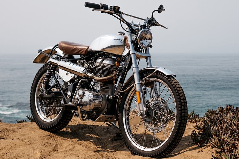 Yes, they do not sell them here anymore but no, people have not forgotten about the Royal Enfield Classic 500. A Los Angeles custom motorcycle shop BAAK, open for less than a year, already has some neat looking builds on its CV. Their latest project involves a Classic 500, reimagined as a vintage trials bike. It’s a homage to the late Johnny Brittain—a celebrated English trials rider who took gold in the 1950 ISDT on a Royal Enfield, at the tender age of 18. (Source: Bikeexif)