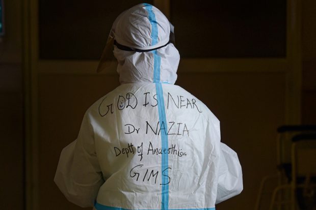 The back of a doctor's PPE kit reads 'GOD IS NEAR' with her name written below to help in identification, at Government Institute of Medical Sciences (GIMS) in Greater Noida on May 25, 2021. (PTI Photo)