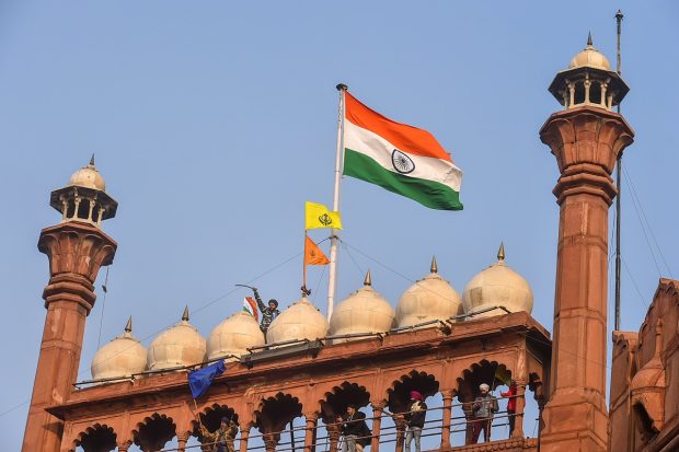 Farmers hoist flags at the Red Fort during the 'tractor rally' amid the 72nd Republic Day celebrations, in New Delhi on January 26, 2021. (PTI Photo)
