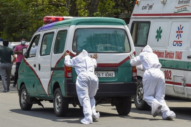 Medics push a stalled ambulance carrying a COVID-19 patient outside Lok Nayak Jaiprakash Narayan Hospital, in New Delhi on April 21, 2021. (PTI Photo)