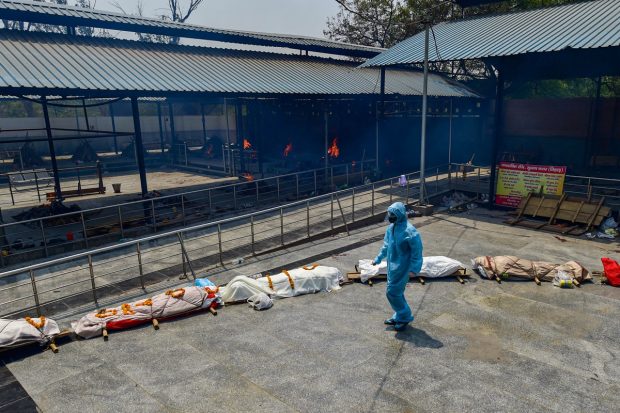 Bodies lined up for cremation at Subhash Nagar Crematorium for the last rites, ,in New Delhi on April 27, 2021. Under the high tin roof, 50 funeral pyres burned fiercely on Tuesday, the hot air filled with smoke, fine ash and muted sobs of shell-shocked famlies. (PTI Photo)