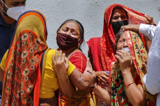 Family members react on the death of a relative, who died of COVID-19, as coronavirus cases surge across the country, outside a mortuary in Ahmedabad on April 18, 2021. (PTI Photo)