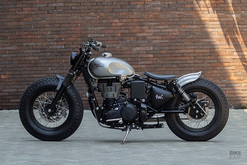 Lighting at the back is handled by tiny LED turn signals attached to the shock mounts, and a side-mounted taillight. FrontWheel also treated the Enfield to a custom skid plate, and new foot pegs. Raijin’s finishes are deliberately monochromatic. Silver paint on the tank and rear fender is complemented by a host of black parts, giving this compact bobber an unassuming vibe. (Source: Bikeexif)