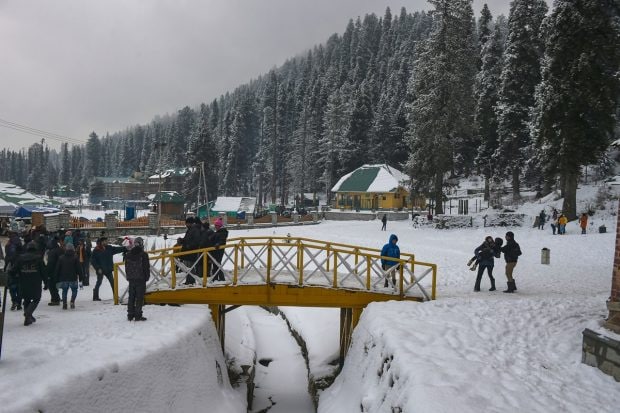 Tourists at the ski resort of Gulmarg during mild snowfall, in Baramulla district of north Kashmir. (PTI Photo)