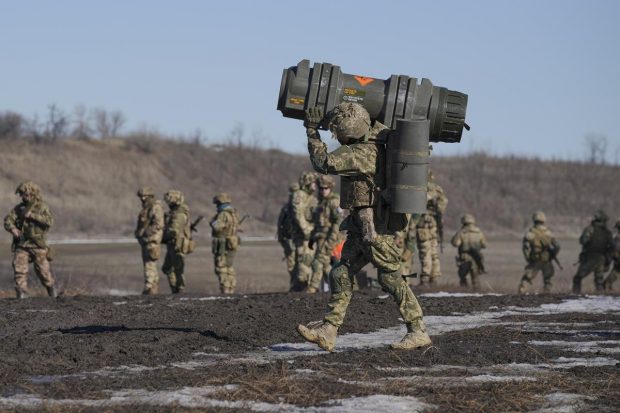 A Ukrainian serviceman carries an NLAW anti-tank weapon during an exercise in the Joint Forces Operation, in the Donetsk region, eastern Ukraine. While the U.S. warns that Russia could invade Ukraine any day, the drumbeat of war is all but unheard in Moscow, where pundits and ordinary people alike don't expect President Vladimir Putin to launch an attack on its ex-Soviet neighbor. (AP Photo)