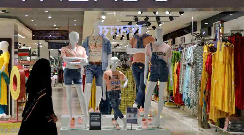 A woman passing by a fashion retail shop in a mall. (File Photo: Reuters)