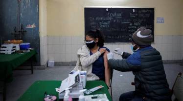 A girl reacts as she receives a dose of Covaxin, a coronavirus disease (COVID-19) vaccine
