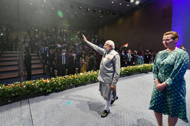 Prime Minister Narendra Modi waves at members of the Indian community as Prime Minister of Denmark Mette Frederiksen looks on, during an event, in Copenhagen, Denmark. (PTI Photo)