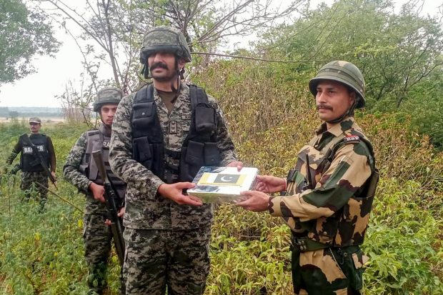 BSF and Pak Rangers exchange sweets at the India-Pakistan International Border on the occasion of Eid-ul-Fitr, on the outskirts of Jammu. (PTI Photo)