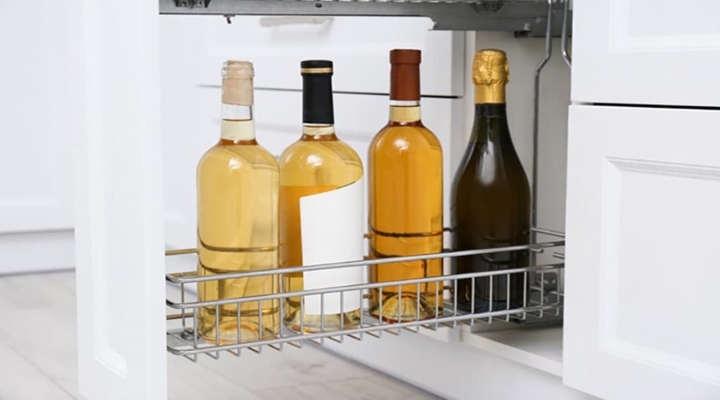 Open drawer with wine bottles in kitchen