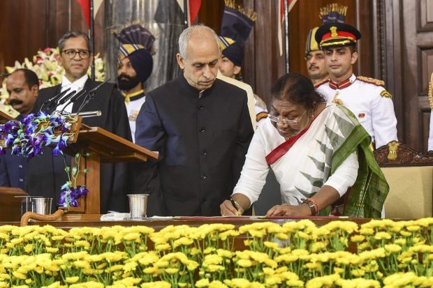 Dressed in a white saree with green and red border, Murmu took the oath of office in the name of God in Hindi to 