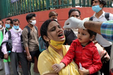 A healthcare worker collects a swab sample from a woman amidst the spread of coronavirus disease (COVID-19), at a bus station, in New Delhi. (Reuters/File Photo)