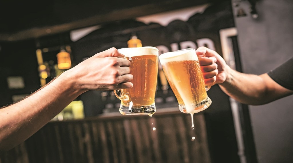 Two people toasting with mugs full of chopp