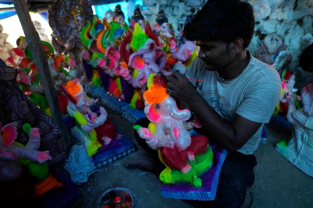 An artist colors an idol of Hindu god Ganesha being prepared for sale ahead of Ganesh Chaturthi festival, in Jammu, India, Monday, Aug. 22, 2022. The idols are in demand ahead of the festival that celebrates the birthday of the elephant headed god. (AP Photo)