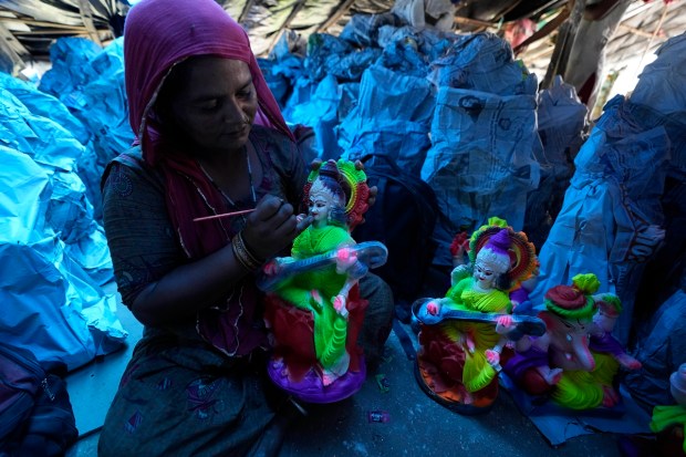 An artist colors an idol of Riddhi, consort of Hindu god Ganesha being prepared for sale ahead of Ganesh Chaturthi festival, in Jammu, India, Monday, Aug. 22, 2022. The idols are in demand ahead of the festival that celebrates the birthday of the elephant headed god. (AP Photo)