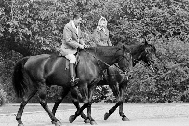 US President Ronald Reagan, on Centennial, and Queen Elizabeth II, on Burmese, go horseback riding in the grounds of Windsor Castle, England, June 8, 1982. (AP Photo)