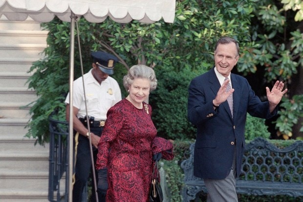 US President George H.W. Bush escorts Queen Elizabeth II from the White House to a helicopter en route to Baltimore to watch her first major league baseball game, in Washington, May 15, 1991. (AP Photo)